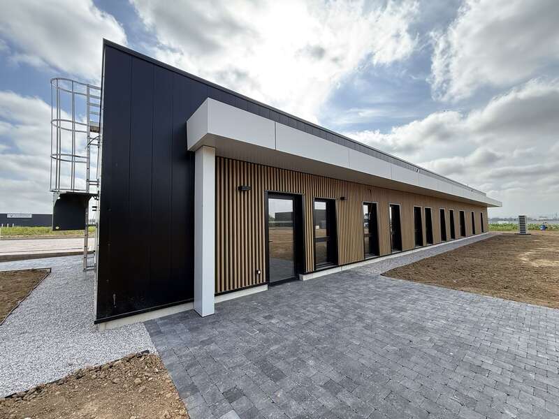 ATPC à Coquelles : bâtiment de plain-pied en bardage Onwood lame ST 300 avec bandeau aluminium et échelle à crinoline