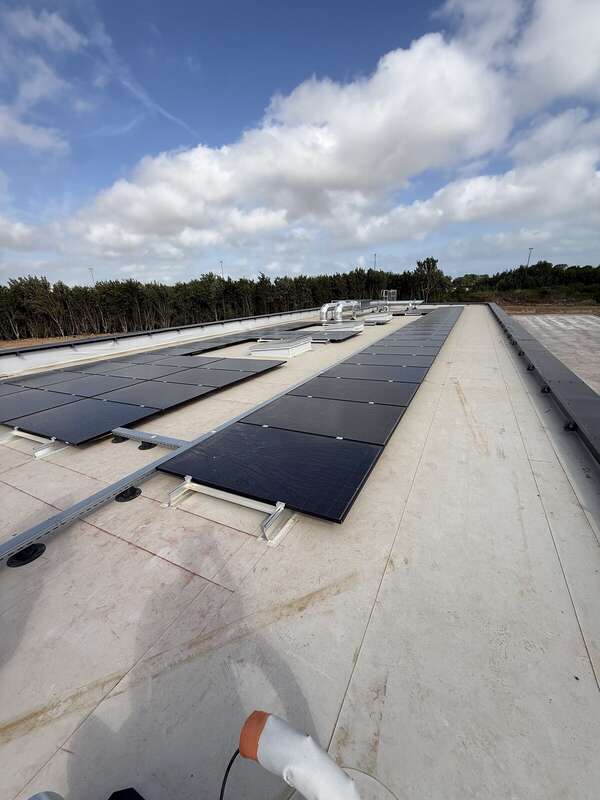 Toiture-terrasse en membrane PVC claire avec supports de panneaux photovoltaïques