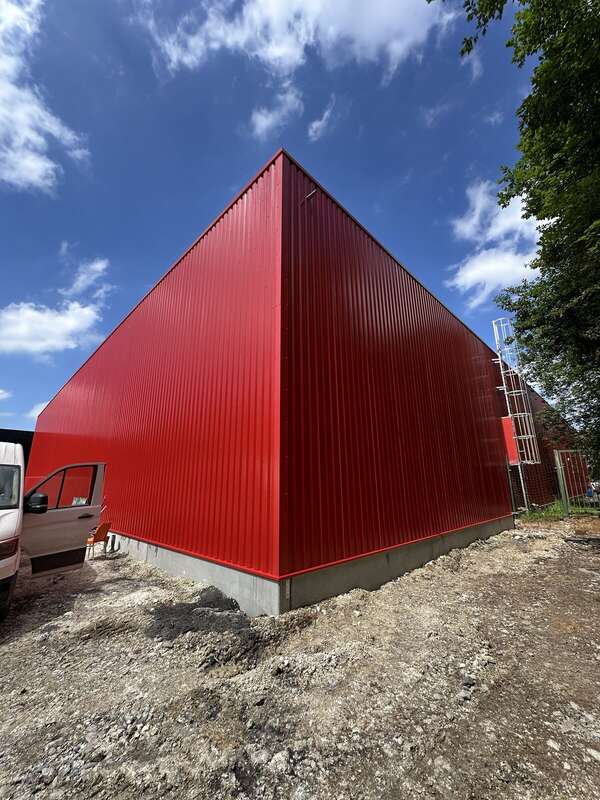 Bâtiment habillé de bardage nervuré rouge